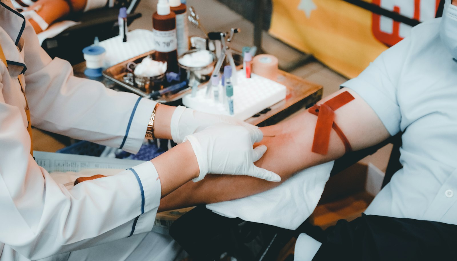 Un'operatrice sanitaria con guanti esegue un prelievo durante una donazione di sangue