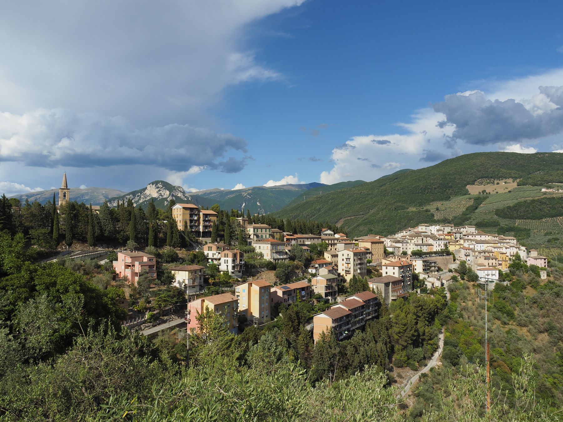 Paesaggio collinare dell'Umbria con un borgo tra il verde